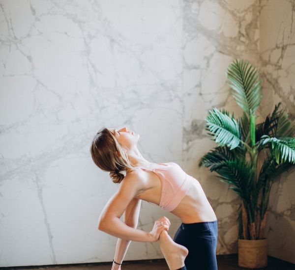 Pregnant woman in a peaceful yoga pose in a bright studio.